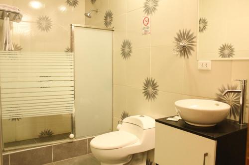 a bathroom with a toilet and a sink and a shower at Hotel B&V in Huancayo