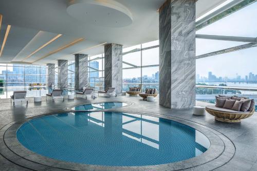 een zwembad in de lobby van het hotel met uitzicht op de stad bij Renaissance Zhuhai Hotel in Zhuhai