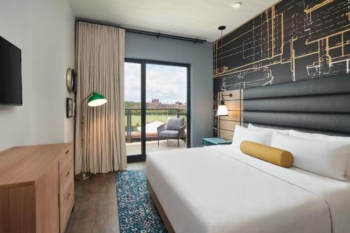 a hotel room with a bed and a large window at Hotel Indigo Tallahassee - Collegetown by IHG in Tallahassee