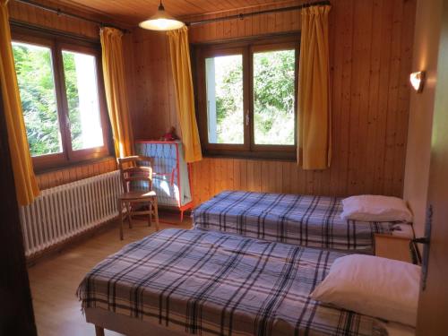 une chambre avec deux lits et deux fenêtres dans l'établissement Appartement familial aux Gets, 2 chambres, parking, Wi-Fi, animaux admis - FR-1-671-88, aux Gets