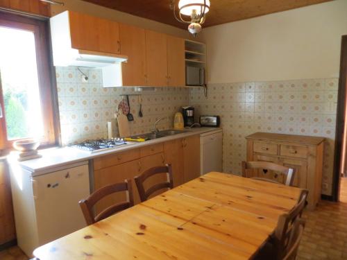 - une cuisine avec une table et une table en bois dans l'établissement Appartement familial aux Gets, 2 chambres, parking, Wi-Fi, animaux admis - FR-1-671-88, aux Gets
