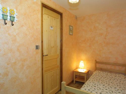 - une petite chambre avec un lit et une porte dans l'établissement Studio cosy, 3 pers, centre Les Gets, Wi-Fi, parking, proche télécabines, non fumeur. - FR-1-671-90, aux Gets