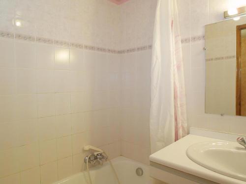 La salle de bains blanche est pourvue d'un lavabo, d'une baignoire et d'un miroir. dans l'établissement Studio cosy, 3 pers, centre Les Gets, Wi-Fi, parking, proche télécabines, non fumeur. - FR-1-671-90, aux Gets