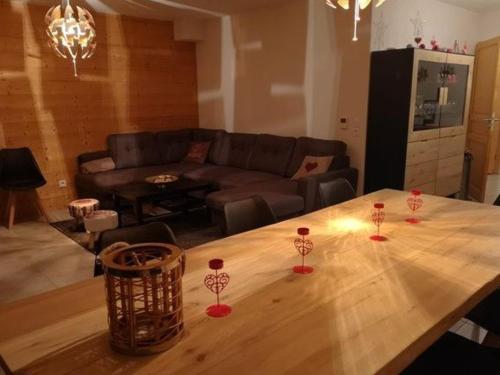 - un salon avec une table en bois et des verres à vin dans l'établissement Spacieux appartement avec Wi-Fi et garage - FR-1-671-241, aux Gets