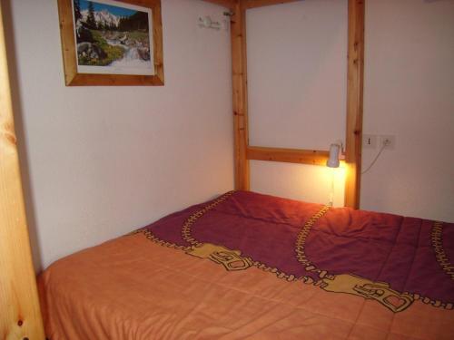 a bedroom with a bed with a chain on it at Appartement cosy avec Wifi, 4 pers, 300m des pistes à Crest-Voland - FR-1-733-141 in Crest-Voland