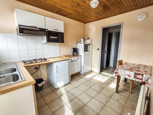 - une cuisine avec des appareils électroménagers blancs et une table dans l'établissement Charmant appartement aux Gets - 5 pers, animaux admis, situé proche des pistes et des commodités - FR-1-671-94, aux Gets
