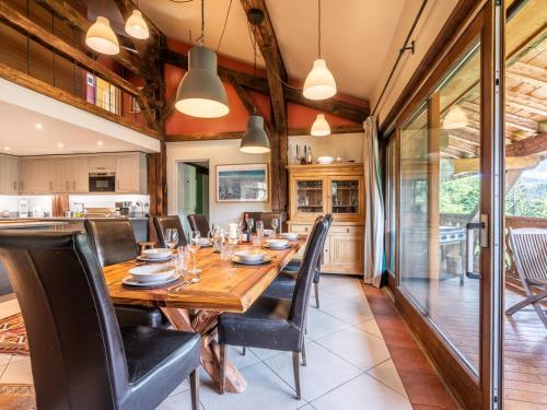 une salle à manger avec une table en bois et des chaises noires dans l'établissement Spacieuse Ferme 6 Chambres aux Gets, 17 Pers, 4 SDB, Balcon, Wi-Fi, Parking Privé, Navette Hiver - FR-1-671-118, aux Gets