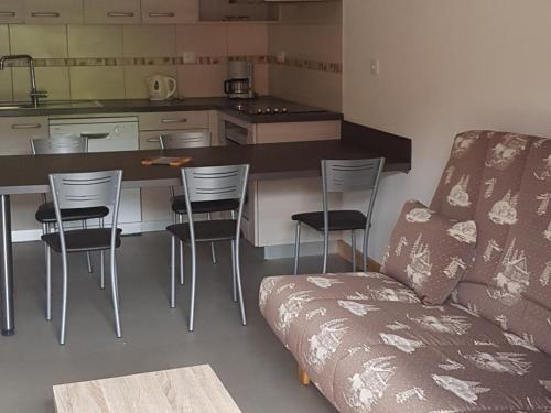 un salon avec un canapé et une cuisine dans l'établissement Appartement cosy aux Gets, proche des pistes, 4 pers, terrasse, parking privatif - FR-1-671-135, aux Gets