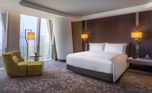 a hotel room with a bed and a chair at Conrad Hangzhou in Hangzhou