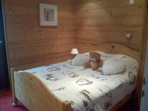 - un ours en peluche assis sur un lit dans une chambre dans l'établissement Appartement Cosy aux Gets - 4 pers, Balcon, Parking Privé, Proche Télécabines et Centre - FR-1-671-103, aux Gets