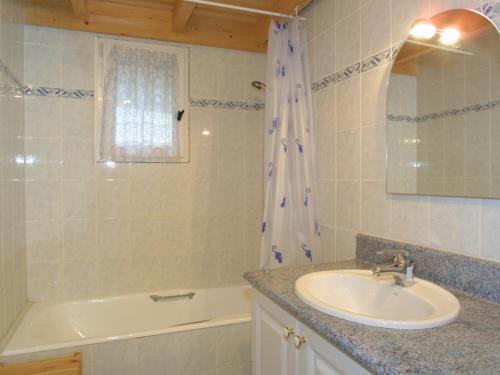 une salle de bain avec un lavabo et une baignoire et un lavabo dans l'établissement Charmant appart. familial avec Wi-Fi, proche ski et centre des Gets, terrasse, garage, animaux admis - FR-1-671-148, aux Gets