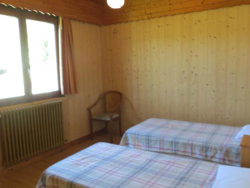 a room with two beds and a window and a chair at Appartement Les Gets, 3 pièces, 6 personnes - FR-1-671-228 in Les Gets