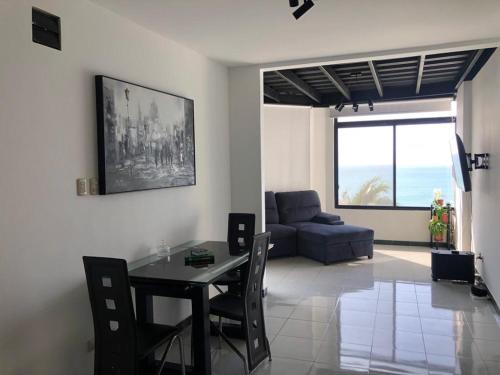 a living room with a table and a couch at Apartamento en excelente ubicación in Manta