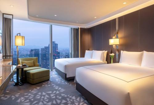 a hotel room with two beds and a window at Conrad Hangzhou in Hangzhou