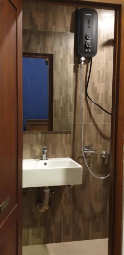 een badkamer met een wastafel en een spiegel bij Kandy City Inn in Kandy