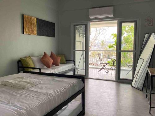 1 Schlafzimmer mit 2 Betten und einem Balkon in der Unterkunft Modern Chic Beachfront Unit at Canyon Cove Nasugbu in Nasugbu