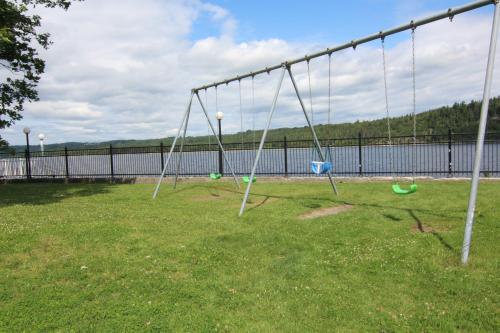 an empty playground with swings in a park at Motel Panoramique in Saguenay