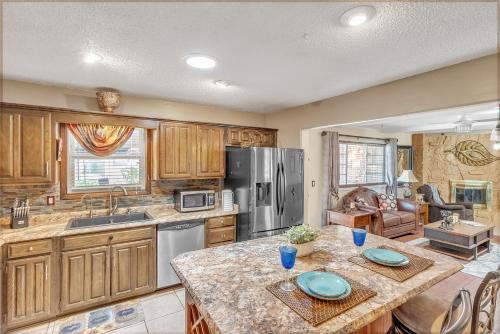una cocina con armarios de madera y una mesa con placas azules. en Cozy 4 Bedroom Home - Minutes to Downtown Tulsa, en Tulsa