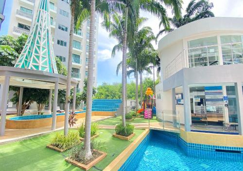 ein Gebäude mit einem Pool neben einem Resort in der Unterkunft Laguna Beach Resort 1 Condominium in Jomtien Beach