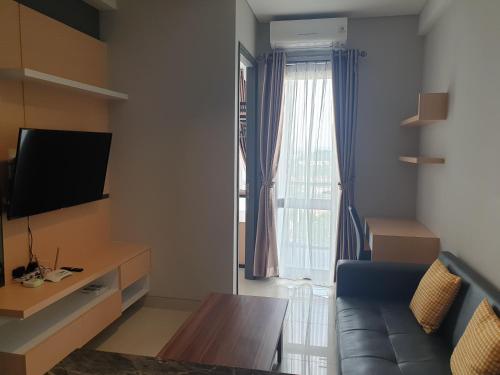 a living room with a couch and a television at CozyHomes at One Residence Batam in Batam Center