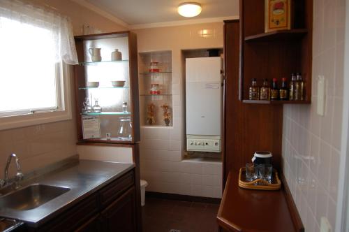 una pequeña cocina con fregadero y nevera. en Torres de Manantiales Apart Hotel en Mar del Plata