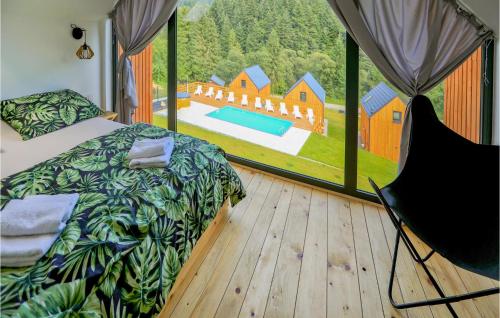 ein Schlafzimmer mit einem großen Fenster mit Blick auf ein Haus in der Unterkunft 2 Bedroom Gorgeous Home In Slopnice in Słopnice