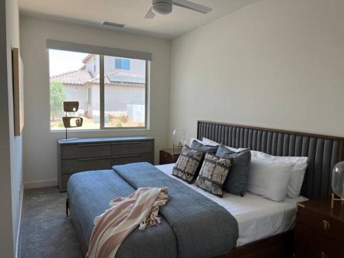 1 dormitorio con cama con almohadas y ventana en PGA West -3 bdrm house w/Bonus Loft, Sleeps 8, Pool, Gym en La Quinta