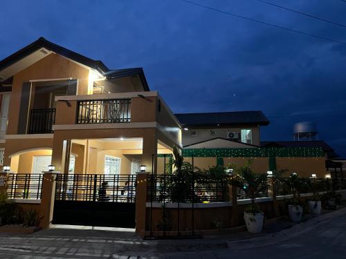 a large house at night with a fence in front of it at DGM AirBnB Urdaneta Pangasinan in Bayaoas