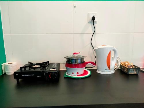 a kitchen counter with a stove and a tea pot and a toaster at D'Aqiela Homestay @ ITCC in Penampang