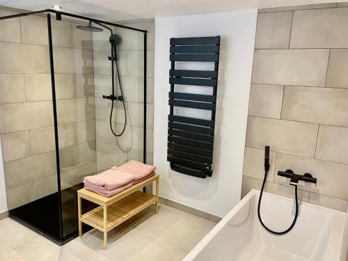 a bathroom with a shower and a bench next to a tub at Chalet Flumet, 6 pièces, 10 personnes - FR-1-505-191 in Flumet