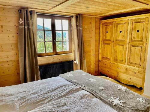 Schlafzimmer mit einem Bett und einem Fenster in der Unterkunft Chalet Flumet, 6 pièces, 10 personnes - FR-1-505-191 in Flumet