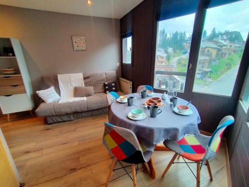 un salon avec une table, des chaises et un canapé dans l'établissement Studio rénové à Avoriaz: 4 pers, avec casier à skis, au cœur du village - FR-1-633-74, à Morzine