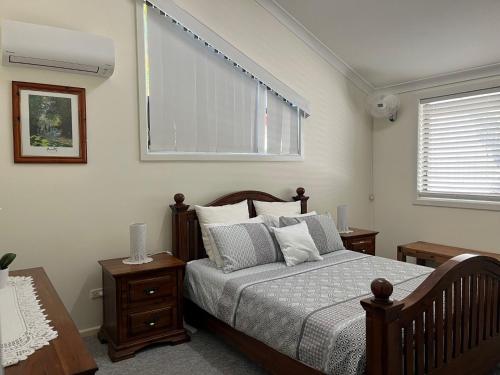 a bedroom with a bed with a window and two tables at 40 Rumbalara Avenue Rainbow Beach in Rainbow Beach