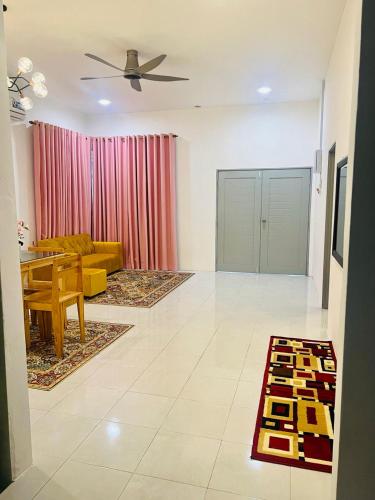 a living room with a table and a couch at Hayyan Homestay Kuala Lipis in Kuala Lipis
