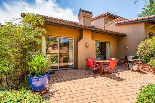 a patio with a table and chairs in front of a house at Uptown Sedona Gem: 3-Bed Townhome with Majestic Views and Central Location in Sedona