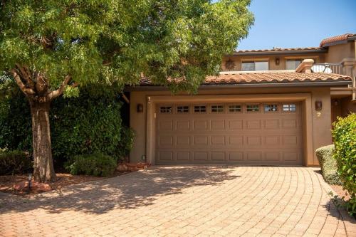 a house with a garage and a tree in front of it at Uptown Sedona Gem: 3-Bed Townhome with Majestic Views and Central Location in Sedona