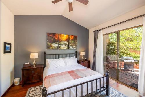 um quarto com uma cama e uma porta de vidro deslizante em Uptown Sedona Gem: 3-Bed Townhome with Majestic Views and Central Location em Sedona