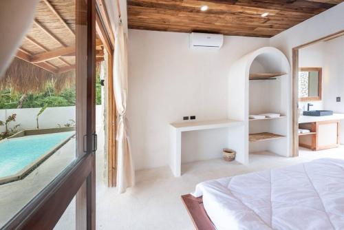 um quarto com uma cama e uma piscina em Villa Baleia Siargao em San Isidro