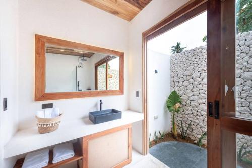 a bathroom with a mirror and a sink at Villa Baleia Siargao in San Isidro