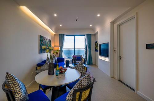 a living room with a table and chairs at Nexus House Ocean front & Hillside Phú Quốc in Phu Quoc