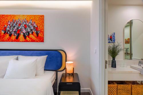 a bedroom with a bed and a bathroom with a sink at Nexus House Ocean front & Hillside Phú Quốc in Phu Quoc