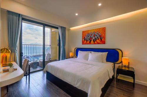 a bedroom with a bed and a desk and a window at Nexus House Ocean front & Hillside Phú Quốc in Phu Quoc