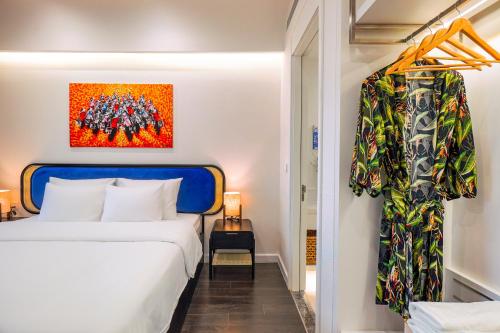 a bedroom with a bed and a painting on the wall at Nexus House Ocean front & Hillside Phú Quốc in Phu Quoc