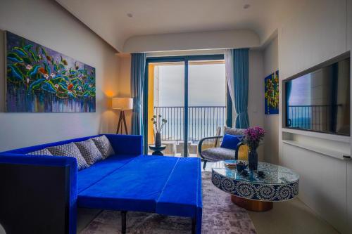 a living room with a blue couch and a table at Nexus House Ocean front & Hillside Phú Quốc in Phu Quoc