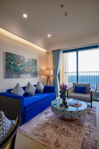 a living room with a blue couch and a table at Nexus House Ocean front & Hillside Phú Quốc in Phu Quoc