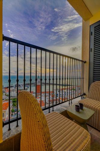 a balcony with two chairs and a view of the ocean at Nexus House Ocean front & Hillside Phú Quốc in Phu Quoc