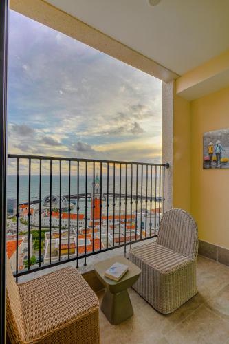 a balcony with two chairs and a view of the ocean at Nexus House Ocean front & Hillside Phú Quốc in Phu Quoc