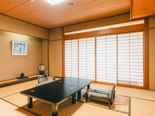 a dining room with a table and two chairs at Hotel Gyokusen in Matsue