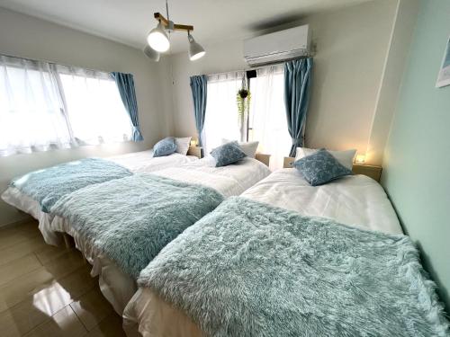 2 letti in una camera con cuscini blu sopra di Naos House Osaka 4 New Open 一軒家貸切 ad Osaka