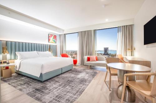 Habitación de hotel con cama y sala de estar. en Holiday Inn & Suites Geelong, an IHG Hotel, en Geelong